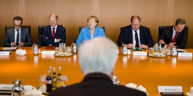 Merkel, Scholz, Maas und andere Politiker sitzen an einem Tisch, Seehofer sitzt ihnen gegenüber (man sieht den Hinterkopf) Merkel, Scholz, Maas und andere Politiker sitzen an einem Tisch, Seehofer sitzt ihnen gegenüber (man sieht den Hinterkopf)