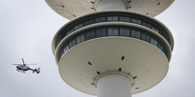 Ein Hubschrauber fliegt neben dem Hamburger Fernsehturm. Ein Hubschrauber fliegt neben dem Hamburger Fernsehturm.