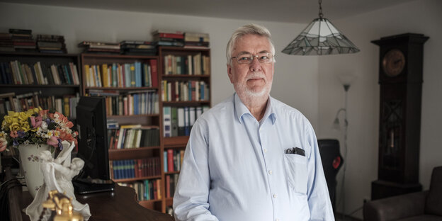 Wolfgang Rosenkötten steht in einer Wohnung vor einem Bücherregal Wolfgang Rosenkötten steht in einer Wohnung vor einem Bücherregal