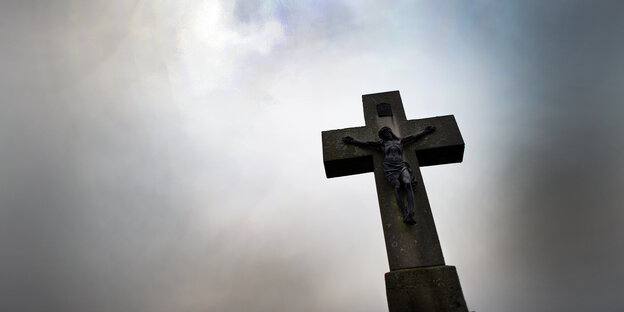 Ein Kreuz, dahinter dunkle Wolken Ein Kreuz, dahinter dunkle Wolken