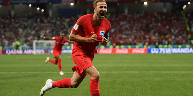 Mann in rotem Trikot rennt über den Rasen - Torschütze Harry Kane Mann in rotem Trikot rennt über den Rasen - Torschütze Harry Kane