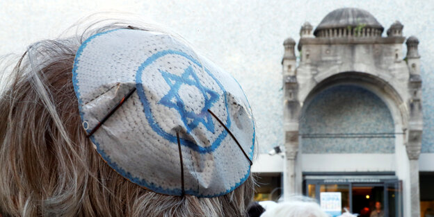 Closeup auf Demonstrierende vor einer Synagoge, die Kippa trägt Closeup auf Demonstrierende vor einer Synagoge, die Kippa trägt