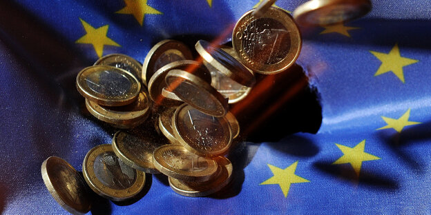 Euro-Münzen fallen auf einen EU-Fahne Euro-Münzen fallen auf einen EU-Fahne