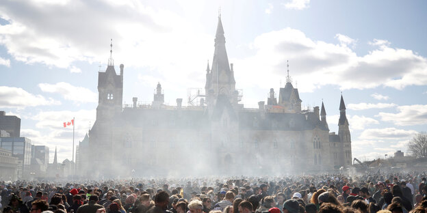 Vor der Legalisierung von Cannabis trafen sich jährlich vor dem Parlament in Ottawa Menschen um für die Legalisierung einzutreten: Vor dem Parlament stehen sehr viele Menschen, das Gebäude ist von Rauch vernebelt Vor der Legalisierung von Cannabis trafen sich jährlich vor dem Parlament in Ottawa Menschen um für die Legalisierung einzutreten: Vor dem Parlament stehen sehr viele Menschen, das Gebäude ist von Rauch vernebelt