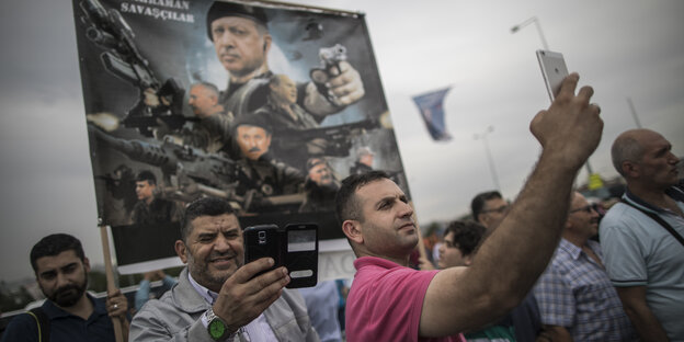 Anhänger von Erdogan posieren vor einem Poster mit dem Konterfeit des Präsidenten für Selfies. Anhänger von Erdogan posieren vor einem Poster mit dem Konterfeit des Präsidenten für Selfies.