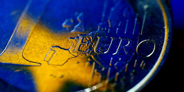 Die Fahne der europäischen Union spiegelt sich in einer Ein-Euro-Münze Die Fahne der europäischen Union spiegelt sich in einer Ein-Euro-Münze