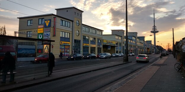 Straßenbahnschienen zwischen Autofahrspuren, dahinter ein Sonnenuntergang Straßenbahnschienen zwischen Autofahrspuren, dahinter ein Sonnenuntergang