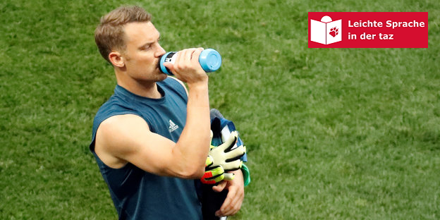 Manuel Neuer steht auf dem Platz und trinkt aus einer Flasche Manuel Neuer steht auf dem Platz und trinkt aus einer Flasche