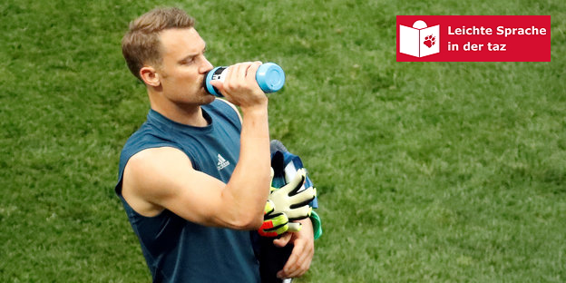 Manuel Neuer steht auf dem Platz und trinkt aus einer Flasche