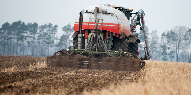 Eine Traktor verteilt Gülle auf einem Feld Eine Traktor verteilt Gülle auf einem Feld
