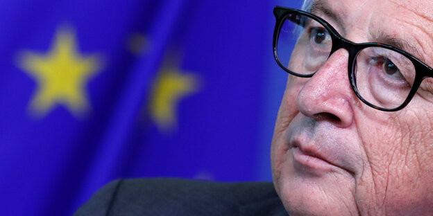 EU-Kommissionschef Jean-Claude Junckers Gesicht vor einer EU-Fahne EU-Kommissionschef Jean-Claude Junckers Gesicht vor einer EU-Fahne