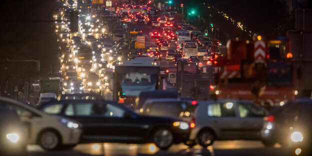 Viele Autos stehen abends im Stau, ihre Lichter leuchten bunt Viele Autos stehen abends im Stau, ihre Lichter leuchten bunt
