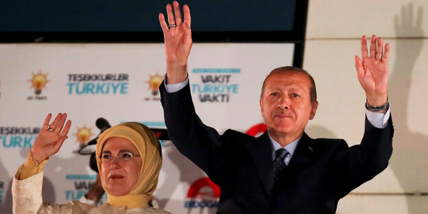 Erdoğan und seine Frau, wie sie die Hände hochheben Erdoğan und seine Frau, wie sie die Hände hochheben