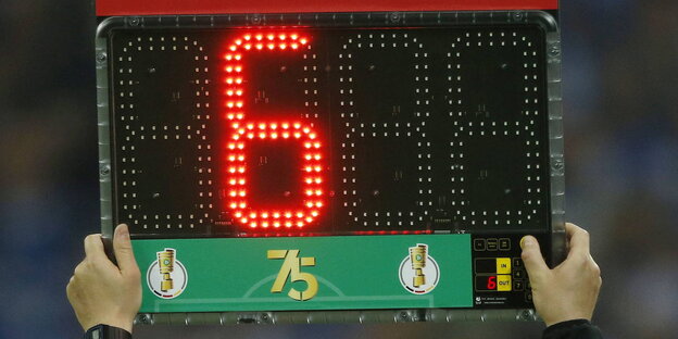 eine Tafel, auf der sechs Minuten Nachspielzeit angezeigt werden eine Tafel, auf der sechs Minuten Nachspielzeit angezeigt werden