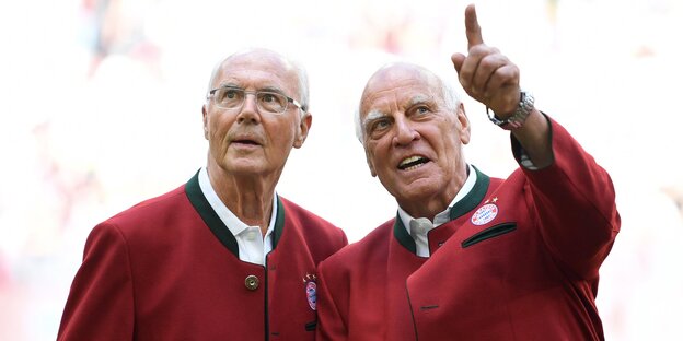 Franz Beckenbauer und eine anderer Mann im Gespräch. Der andere Mann zeigt in eine bestimmte Richtung Franz Beckenbauer und eine anderer Mann im Gespräch. Der andere Mann zeigt in eine bestimmte Richtung