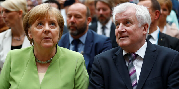 Bundeskanzlerin Angela Merkel und Innenminister Horst Seehofer sitzen bei einer Veranstaltung Bundeskanzlerin Angela Merkel und Innenminister Horst Seehofer sitzen bei einer Veranstaltung