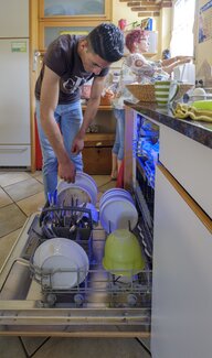 Flüchtling Juody räumt die Spülmaschine ein Flüchtling Juody räumt die Spülmaschine ein