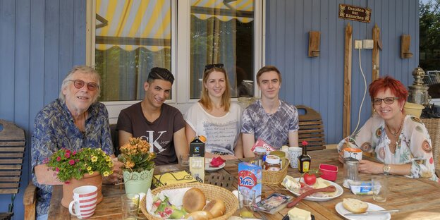 Die Familie Bernhardt sitzt mit dem syrischen Flüchtling Juody am Frühstückstisch