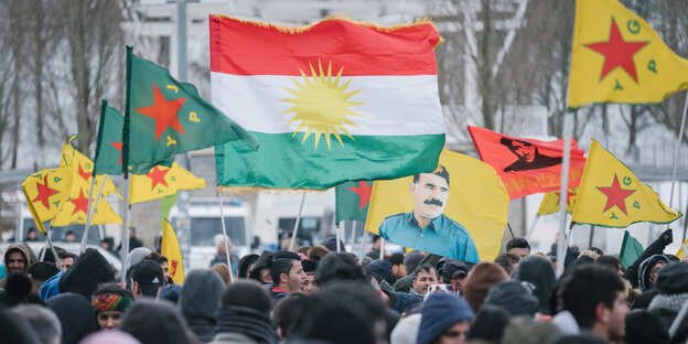 Eine Demonstration mit einer Fahne, die Abdullah Öcalan zeigt Eine Demonstration mit einer Fahne, die Abdullah Öcalan zeigt