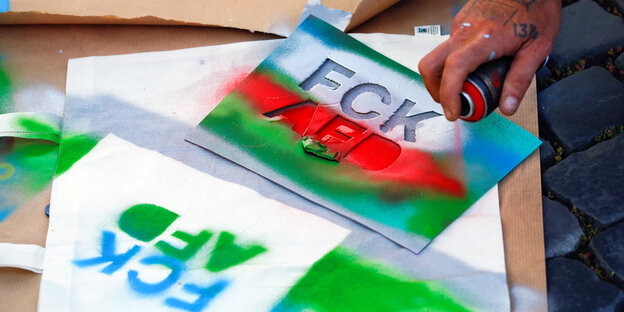 Eine Schablone in Rot, Blau und Grün, mit der sich die Buchstaben FCK AFD drucken lassen Eine Schablone in Rot, Blau und Grün, mit der sich die Buchstaben FCK AFD drucken lassen