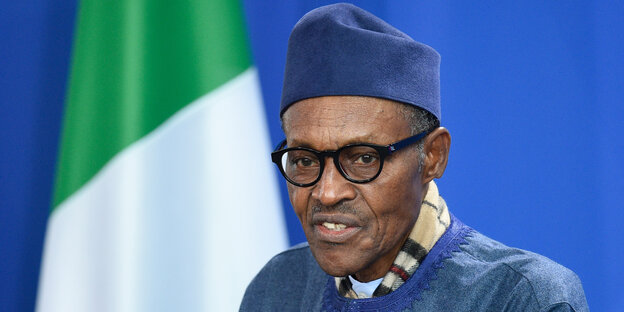 Der Präsident Nigerias, Muhammadu Buhari, steht vor der nigerianischen Flagge Der Präsident Nigerias, Muhammadu Buhari, steht vor der nigerianischen Flagge