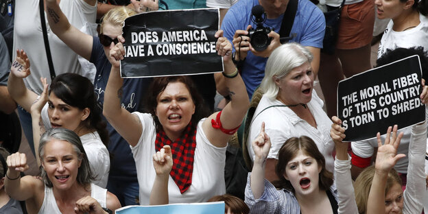 Protest gegen die US-Einwanderungspolitik - Frauen sitzen auf dem Boden, eine hält ein Schild hoch mit der Aufschrift "Does America have a conscience" - "Hat Amerika ein Gewissen" Protest gegen die US-Einwanderungspolitik - Frauen sitzen auf dem Boden, eine hält ein Schild hoch mit der Aufschrift "Does America have a conscience" - "Hat Amerika ein Gewissen"