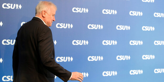 Horst Seehofer geht vor einer blauen Wand entlang, auf die das CSU-Logo als Muster gedruckt ist Horst Seehofer geht vor einer blauen Wand entlang, auf die das CSU-Logo als Muster gedruckt ist