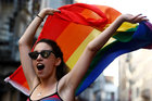 Eine Frau schwenkt eine Regenbogen-Fahne