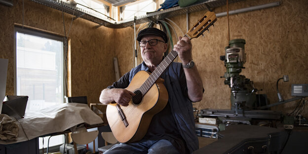Karl Thiel sitzt mit seiner Gitarre in seiner Werkstatt Karl Thiel sitzt mit seiner Gitarre in seiner Werkstatt