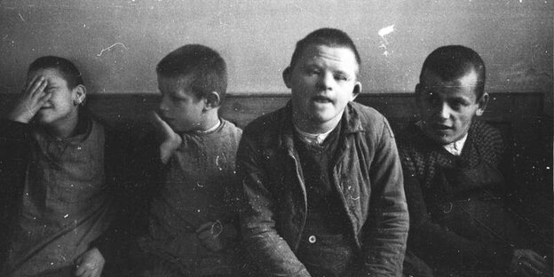 Vier Kinder mit Down-Syndrom auf einer historischen Schwarz-Weiß-Fotografie Vier Kinder mit Down-Syndrom auf einer historischen Schwarz-Weiß-Fotografie