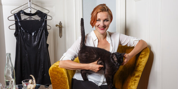 Kristina Marlen hält lächelnd eine Katze auf dem Schoß Kristina Marlen hält lächelnd eine Katze auf dem Schoß
