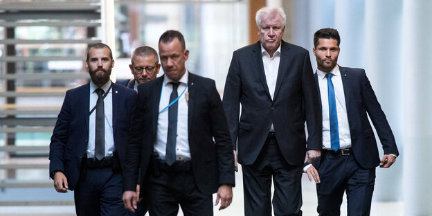 Innenminister Horst Seehofer geht mit Mitarbeitern einen Gang entlang Innenminister Horst Seehofer geht mit Mitarbeitern einen Gang entlang