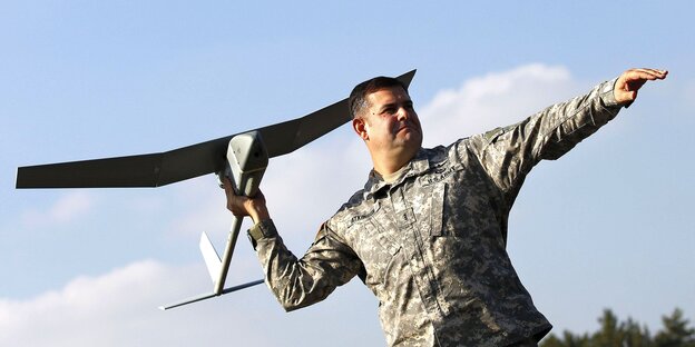 Ein US-Soldat hält eine Flugzeugdrohne in der Hand. Er befindet sich in Deutschlad. Er ist kurz davor die Drohne in Richtung Himmel starten zu lassen. Ein US-Soldat hält eine Flugzeugdrohne in der Hand. Er befindet sich in Deutschlad. Er ist kurz davor die Drohne in Richtung Himmel starten zu lassen.