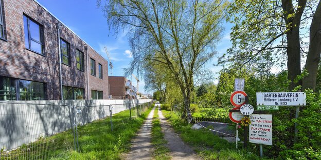 Neue Flachbauten stehen neben einem Feldweg Neue Flachbauten stehen neben einem Feldweg