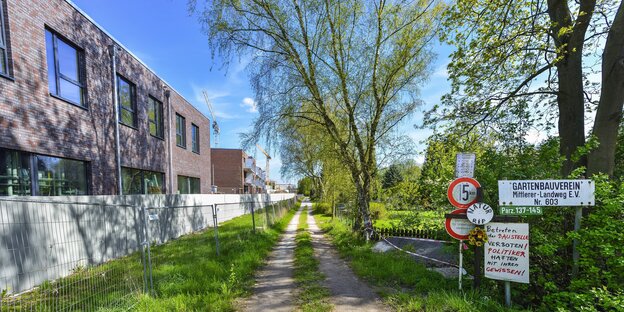 Neue Flachbauten stehen neben einem Feldweg