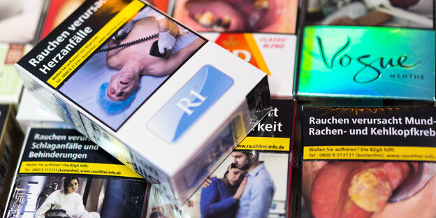 Zigarettenschachteln mit Schockbildern liegen auf einem Tresen in einem Kiosk Zigarettenschachteln mit Schockbildern liegen auf einem Tresen in einem Kiosk