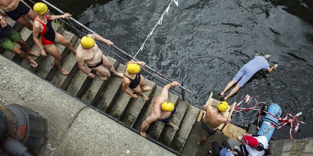 Schwimmer auf dem Weg treppab zum Wasser Schwimmer auf dem Weg treppab zum Wasser