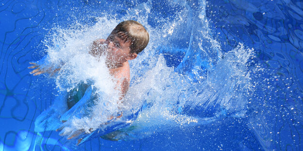 Kind planscht in einem Schwimmbecken Kind planscht in einem Schwimmbecken