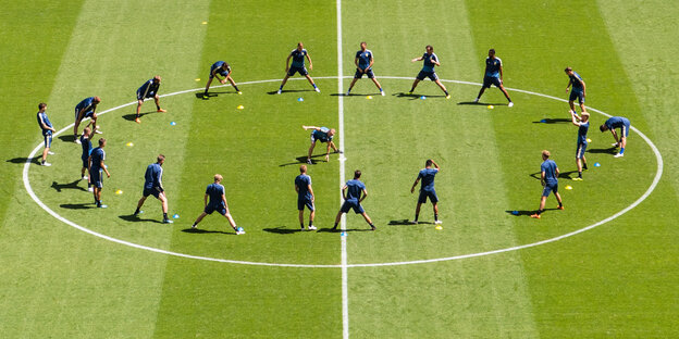 Viele Spieler im Mittelkreis eines Spielfelds Viele Spieler im Mittelkreis eines Spielfelds
