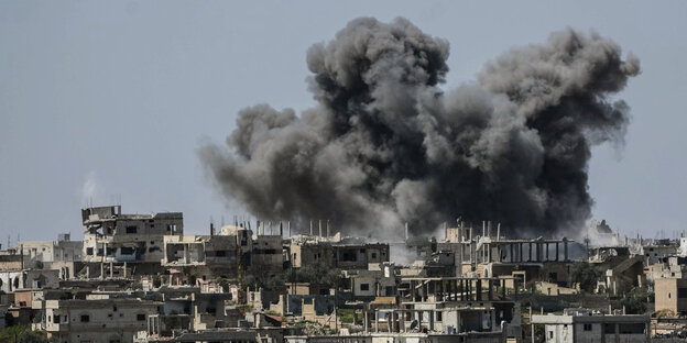 Eine graue Rauchwolke über einer syrischen Stadt Eine graue Rauchwolke über einer syrischen Stadt