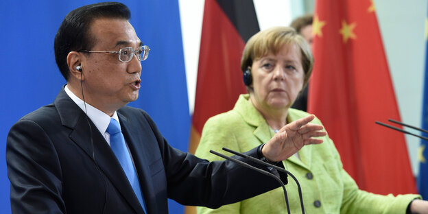 Chinas Ministerpräsident Li im schwarzen Anzug neben Angela Merkel, die einen apfelgrünes Jackett trägt Chinas Ministerpräsident Li im schwarzen Anzug neben Angela Merkel, die einen apfelgrünes Jackett trägt