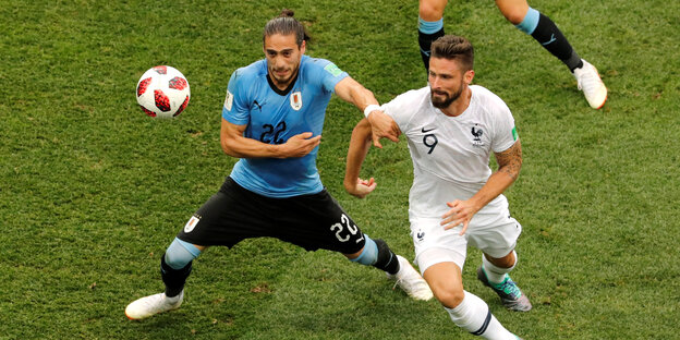 Der Franzose Olivier Giroud und Uruguayer Martin Caceres in Aktion. Der Franzose Olivier Giroud und Uruguayer Martin Caceres in Aktion.