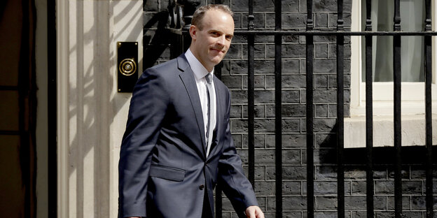 Dominic Raab trägt einen Anzug und schaut entschlossen Dominic Raab trägt einen Anzug und schaut entschlossen