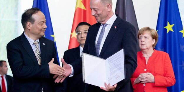 Bundeskanzlerin Angela Merkel und Chinas Ministerpräsident Li Keqiang stehenhinter Wolfgang Tiefensee, Wirtschaftsminister von Thüringen, und Zeng Yuqun, Geschäftsführer von Contemporary Amperes Technology Bundeskanzlerin Angela Merkel und Chinas Ministerpräsident Li Keqiang stehenhinter Wolfgang Tiefensee, Wirtschaftsminister von Thüringen, und Zeng Yuqun, Geschäftsführer von Contemporary Amperes Technology