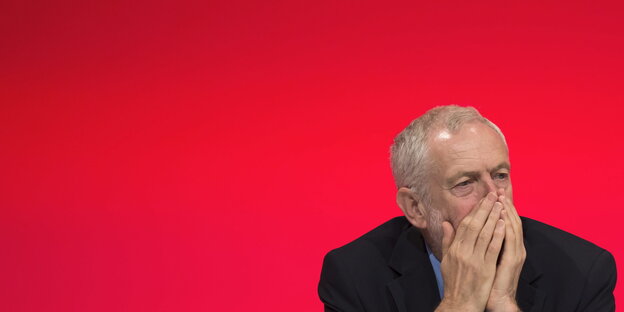 Jeremy Corbyn vor roter Wand