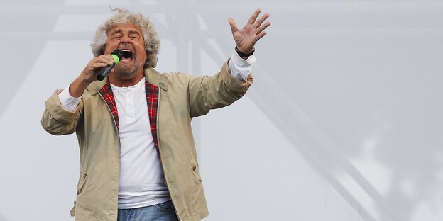 Beppe Grillo von der italienischen Fünf-Sterne-Bewegung spricht auf einer Bühne Beppe Grillo von der italienischen Fünf-Sterne-Bewegung spricht auf einer Bühne