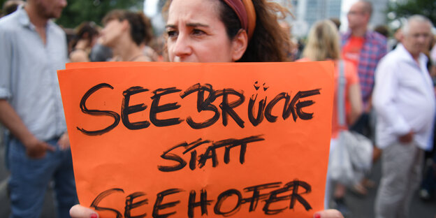 Eine Demonstrantin hält ein Schild, auf dem steht "Seebrücke statt Seehofer" Eine Demonstrantin hält ein Schild, auf dem steht "Seebrücke statt Seehofer"