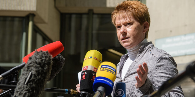 Petra Pau steht vor Mikrofonen und spricht Petra Pau steht vor Mikrofonen und spricht