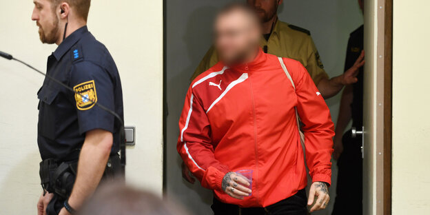 André Eminger betritt den Gerichtsaal. Sein Gesicht ist gepixelt André Eminger betritt den Gerichtsaal. Sein Gesicht ist gepixelt