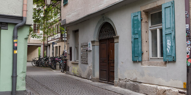 Hölzerne eingangstür in ein altes kleines Haus in einer engen Gasse Hölzerne eingangstür in ein altes kleines Haus in einer engen Gasse